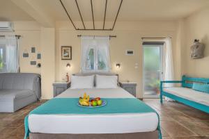 a bedroom with a bed with a plate of fruit on it at Kalokairi Boutique Residence in Skopelos Town +108 photos