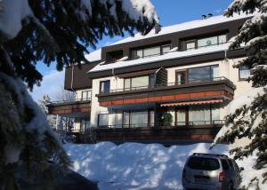 un edificio con un coche aparcado delante en Welcome in - Apartments Am Waltenberg 57-59, en Winterberg