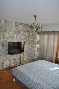 a bedroom with a bed and a stone wall at Chambre d'hôte l'Argentier in Noyarey