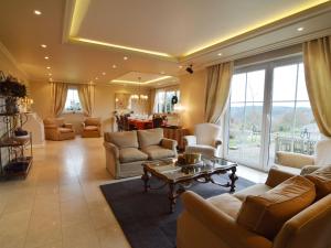 ein großes Wohnzimmer mit Sofas und einem Tisch in der Unterkunft Enticing Holiday Home in Malmedy with Sauna in Malmedy