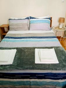 a bed with two white towels sitting on it at Anatoli's house in Kastoria