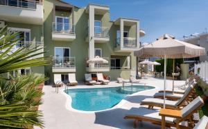 a villa with a swimming pool in front of a building at Lafeyra Hotel in Limenaria