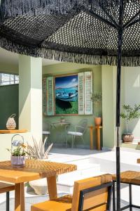 a patio with tables and chairs and a painting of a boat at Lafeyra Hotel in Limenaria