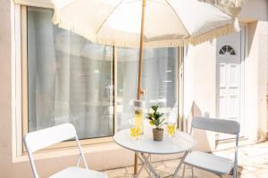 a table with two chairs and an umbrella at Nüma Studio - Orly Paris in Montgeron