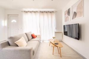 a living room with a couch and a tv at Nüma Studio - Orly Paris in Montgeron