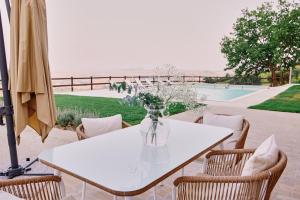 a white table with chairs and a vase of flowers at Villa Elena in San Severino Marche +28 photos