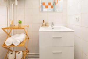 a white bathroom with a sink and towels at Nüma Studio - Orly Paris in Montgeron +12 photos