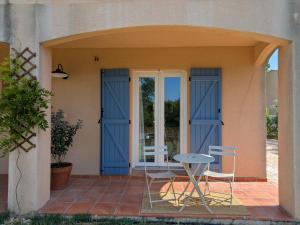 a patio with blue doors and a table and chairs at Villa Salesiae in Les Salles-sur-Verdon