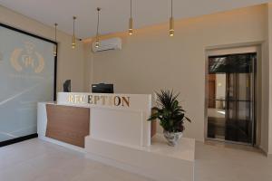 a reception desk in a building with a potted plant at Hotel Danedi in Ksamil