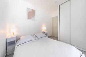 a bedroom with a white bed and a large mirror at Nüma Studio - Orly Paris in Montgeron