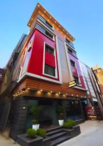 a red building with plants in front of it at Mohar Residency - VIP Road in kolkata