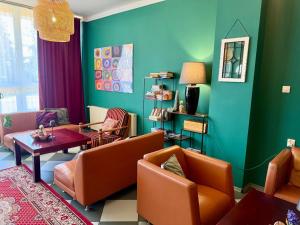 a living room with orange chairs and a green wall at Interferie Chalkozyn w Kołobrzegu in Kołobrzeg