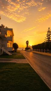 a house on the side of a road with the sunset at Salsedo Seaside Rooms 2 in Kanali