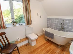 a bathroom with a tub and a toilet and a window at 5 Castle Street in Newport +23 photos