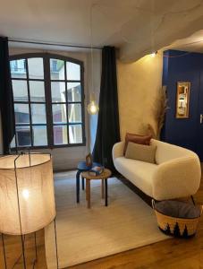 a living room with a couch and a table at Le Petit Horloge, Hyper centre de Rennes in Rennes