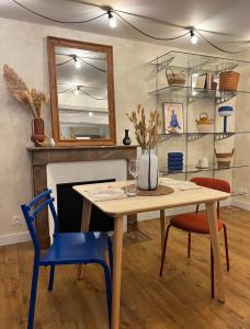 a dining room with a table and chairs and a fireplace at Le Petit Horloge, Hyper centre de Rennes in Rennes