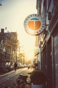 un cartel para una cafetería en una calle de la ciudad en Budget Hotel Tourist Inn, en Ámsterdam