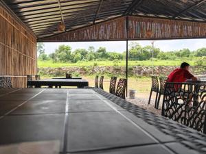 a man sitting at a table in a barn at Heijo's Travellers Nest in Jarain +6 photos