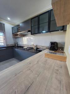 a large kitchen with a wooden counter top at Ednomis Apartment in Mazabuka