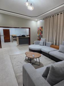a living room with couches and a coffee table at Ednomis Apartment in Mazabuka