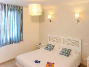 a bedroom with a white bed with two pillows at Appartement 3 étoiles - ccbgeff in Cabriès