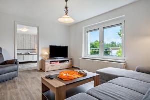 a living room with a couch and a tv at Ferienwohnung 2 in Gribow