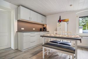 a kitchen with white cabinets and a table and chairs at Ferienwohnung 2 in Gribow