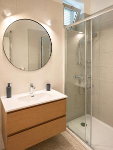 a bathroom with a sink and a shower with a mirror at Rab Pandelo Apartmani in Rab