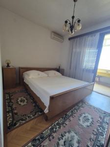 a large bed in a bedroom with a rug at Guest House Čović in Tučepi +4 photos