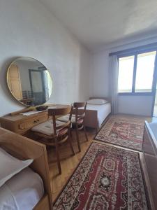 a room with a mirror and a table and a bed at Guest House Čović in Tučepi