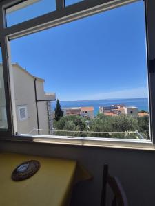 a window with a view of the ocean at Guest House Čović in Tučepi