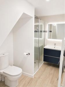 a white bathroom with a toilet and a sink at Duplex de charme au coeur de Beaugency in Beaugency
