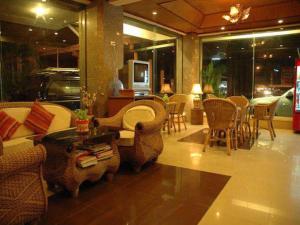 Una sala de estar con sillas, un sofá y una mesa. en Kraisaeng Place, en Phitsanulok