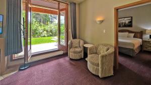 a hotel room with a bed and two chairs at Cahilty #149 in Sun Peaks