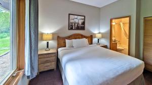 a bedroom with a large white bed and a window at Cahilty #149 in Sun Peaks