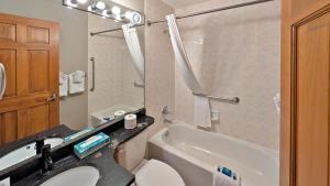 a bathroom with a toilet and a sink and a tub at Cahilty #149 in Sun Peaks