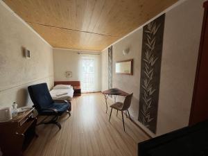 ein Zimmer mit einem Bett, einem Stuhl und einem Tisch in der Unterkunft Dom Wakacyjny Karol in Łeba