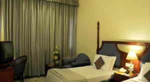 a hotel room with a bed and a television at Ohris Baseraa in Hyderabad