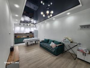 a living room with a green couch and a kitchen at Коттедж в Sunny Beach in Chok-Tal