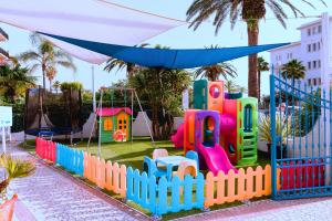 a playground in a park with a colorful fence at Hotel Ambassador in Grottammare