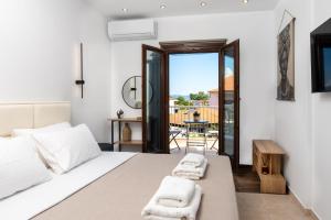 a bedroom with a bed and a balcony at Kallisti Luxury Rooms in Ierissos