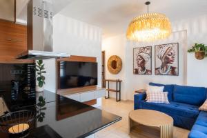 a living room with a blue couch and a tv at Kallisti Luxury Rooms in Ierissos