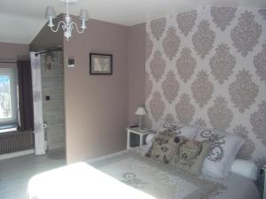a bedroom with a bed and a wall at Au Vieux Logis 63 in Saint-Rémy-sur-Durolle