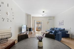a living room with a blue couch and a table at VALERIA Apartment in Vonitsa