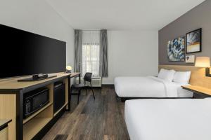 a hotel room with two beds and a flat screen tv at City Express by Marriott Yulee in Yulee