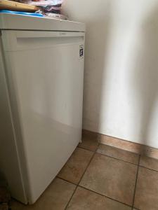 a small white refrigerator in a corner of a room at Seehaus Simssee in Stephanskirchen