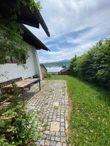 a stone path with a bench next to a building at Seehaus Simssee in Stephanskirchen