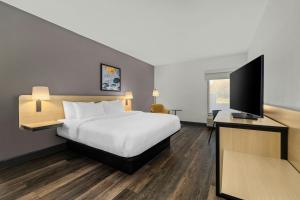 a hotel room with a bed and a flat screen tv at City Express by Marriott Yulee in Yulee