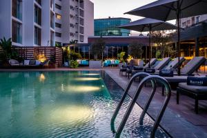 a swimming pool with lounge chairs and an umbrella at Barceló Anfa Casablanca in Casablanca