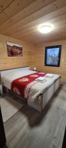 a bedroom with a bed in a wooden cabin at Chalet avec jacuzzi privé, 3 chambres in Traubach-le-Haut